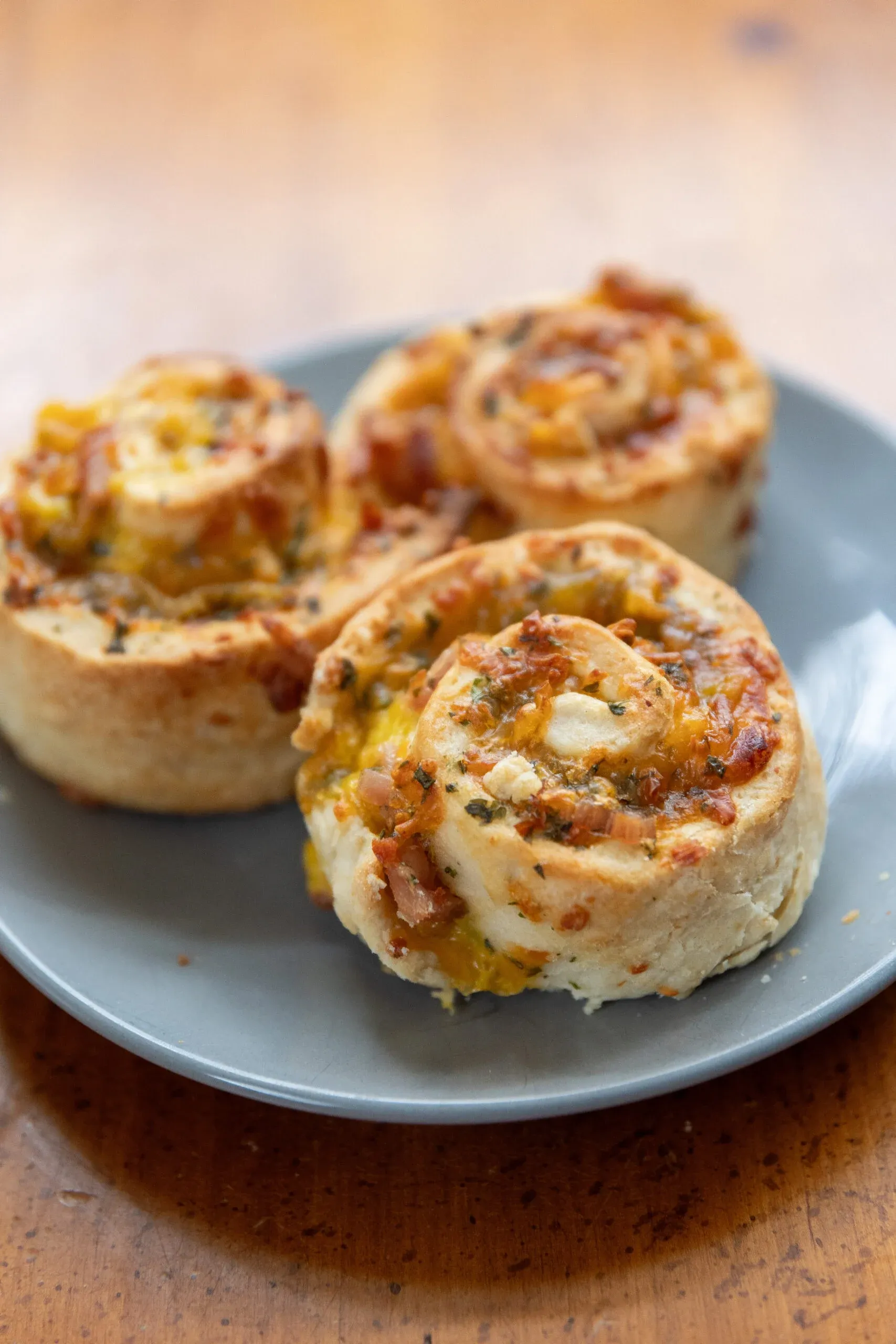 These ham and cheese roll-up biscuits are warm, cheesy, and seriously hard to resist. Soft biscuit dough is rolled up with savory ham and cheese, then finished with a rich homemade cheese sauce for extra comfort-food appeal. Easy to grab, fun to eat, and filling enough to satisfy a crowd, they work just as well for parties and game day as they do for a cozy family meal.