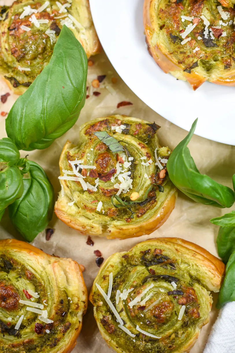 These pesto puff pastry pinwheels are simple, savory, and full of flavor. Made with pesto, fresh basil, Parmesan, and a pinch of chili flakes, they only need six ingredients and come together with very little effort. Flaky, cheesy, and easy to serve, they’re a great go-to pinwheel appetizer for parties and game day.