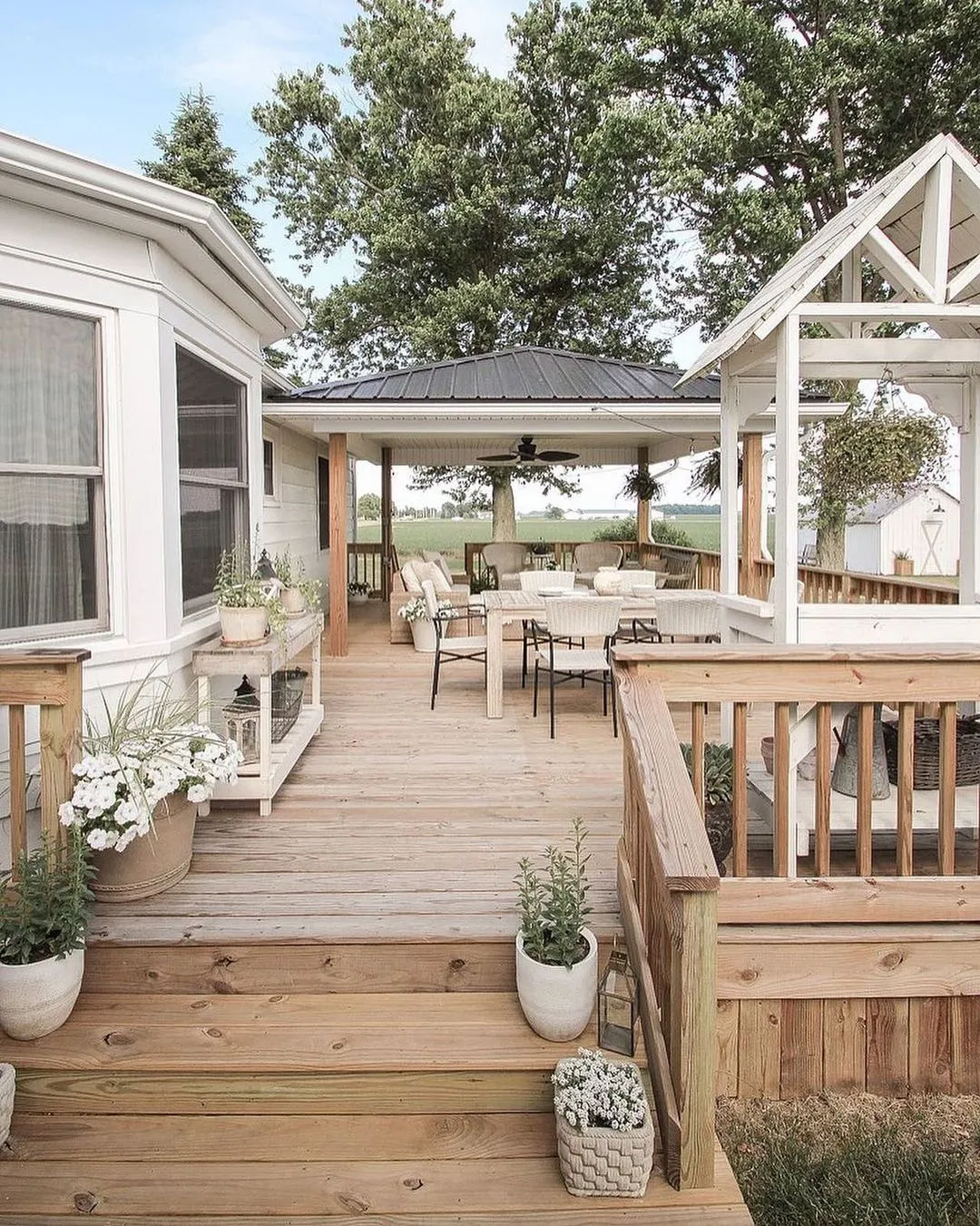This simple backyard deck with a covered dining area is a lovely option if you want something timeless that won’t date quickly. The natural wood decking, basic railings, and soft decor keep it relaxed and welcoming, while the roofed section makes it practical for everyday use — rain or shine. This style works especially well for ground-level backyard deck ideas or gently stepped layouts, and it’s ideal for families who use their deck daily rather than just for entertaining. It’s also a great example of backyard deck ideas on a budget simple, where the structure does the work and the decor stays minimal and easy to update over time.