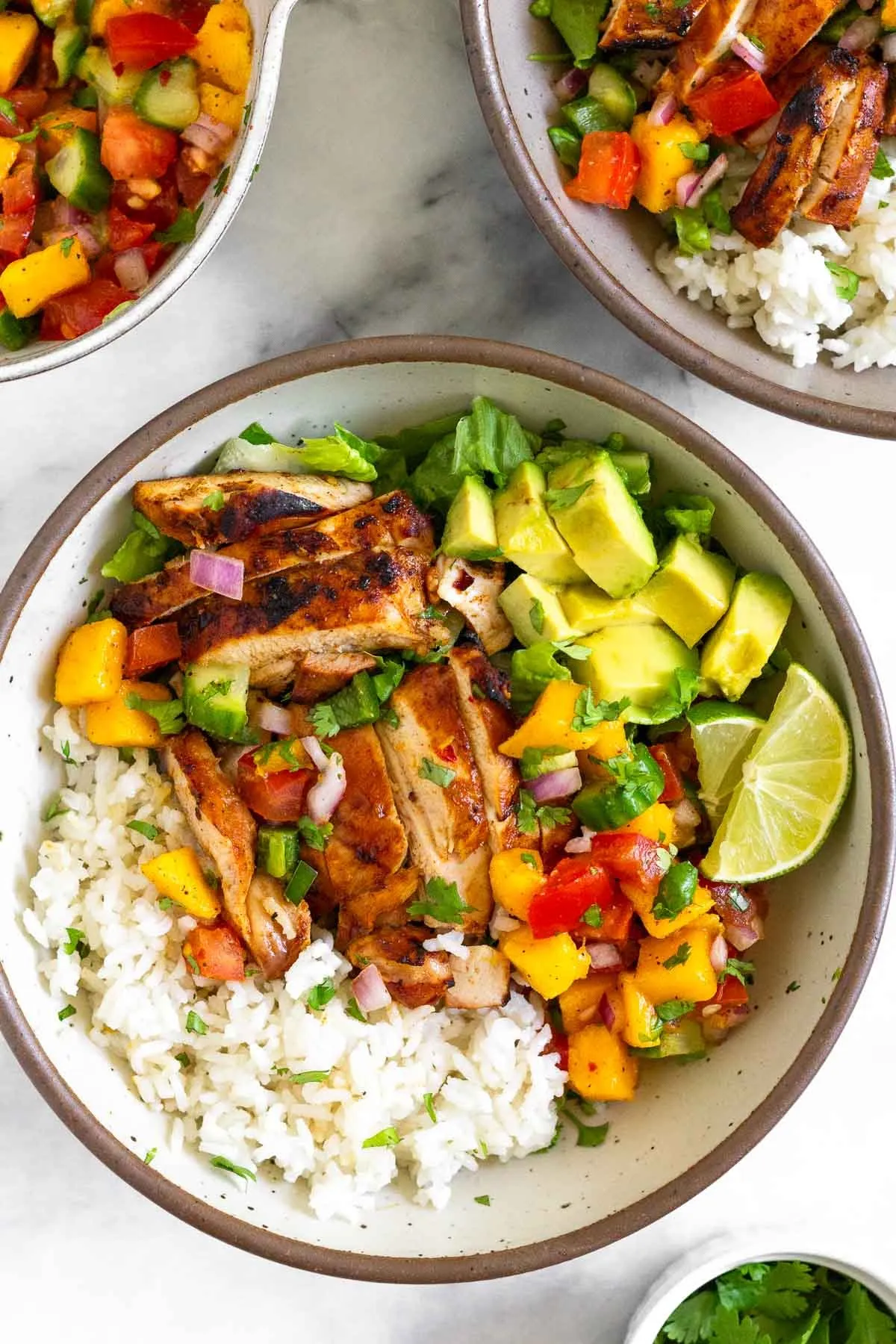 This mango chicken rice bowl is fresh, colorful, and perfect for warm-weather meals. Sweet and lightly spiced chicken is paired with coconut rice, juicy mango salsa, and creamy avocado for a balanced bowl that works just as well for easy dinners as it does for meal prep.