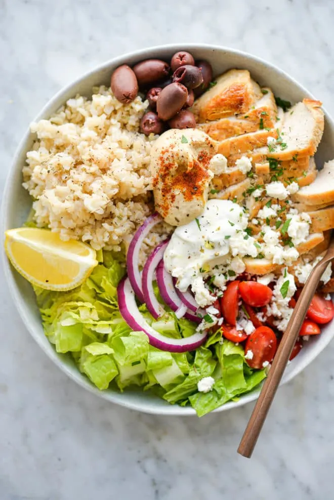 These Greek-style chicken rice bowls are made with tender sliced chicken, fluffy rice, fresh greens, olives, hummus, tzatziki, and a light Greek-style dressing. They’re fresh, filling, and easy to put together for quick dinners or meal prep.