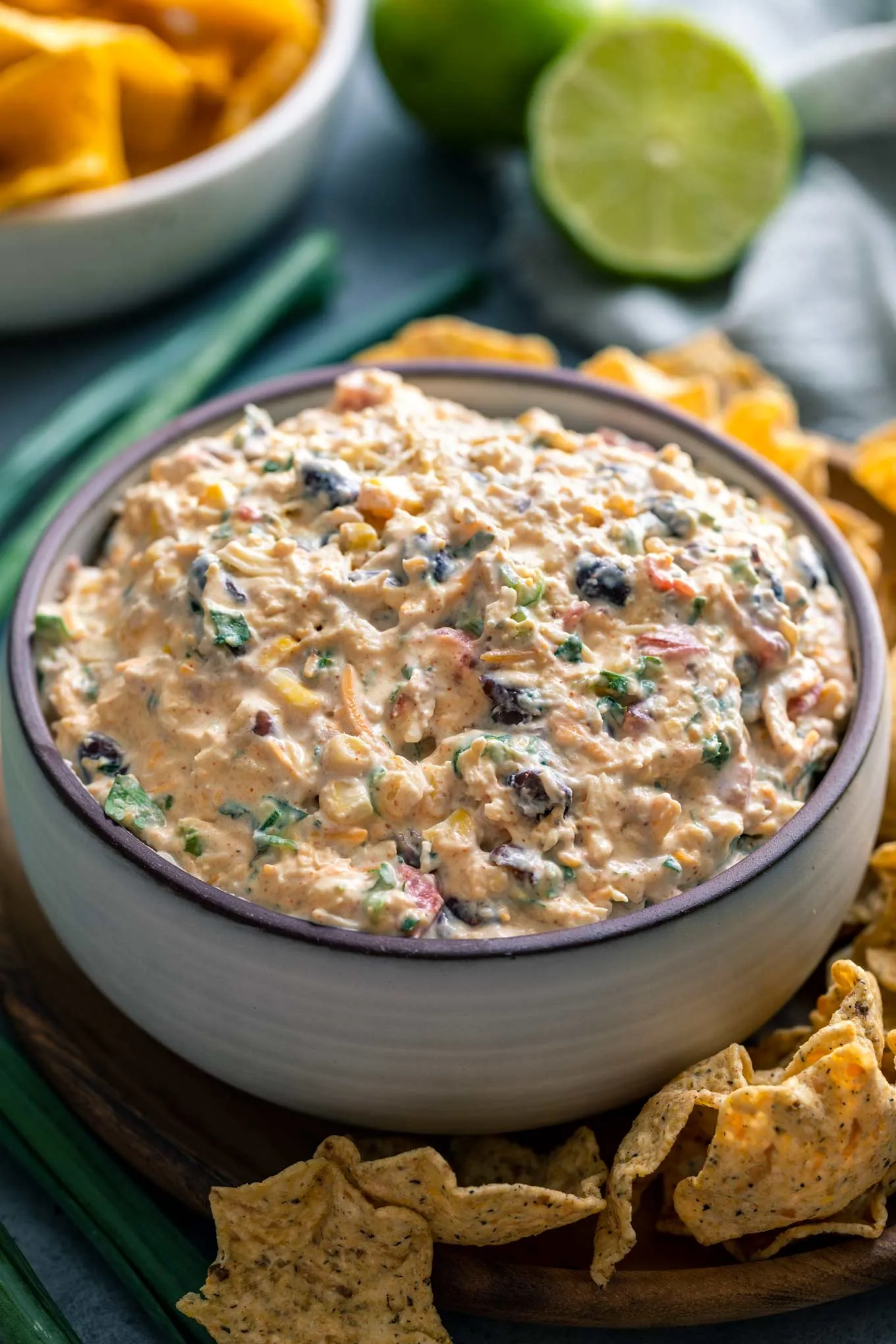 Creamy with a kick, this chicken taco dip is made with simple ingredients, is perfect to make-ahead, and is completely no-bake. Be party ready in no time!  Chicken, cream cheese, taco seasoning, black beans, corn, and more all combine to make the most delicious dip ever!