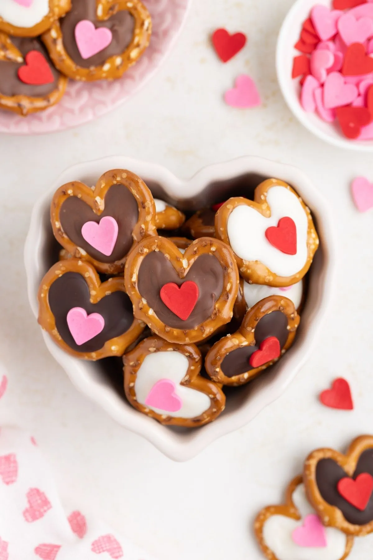These heart pretzels are the easiest way to keep Valentine’s gifting simple and sweet. Mini pretzel twists get filled with melted chocolate and topped with a festive heart sprinkle for a no-bake treat that comes together fast. Perfect for homemade gifts, classroom treats, or a quick Valentine’s snack that still feels special.
