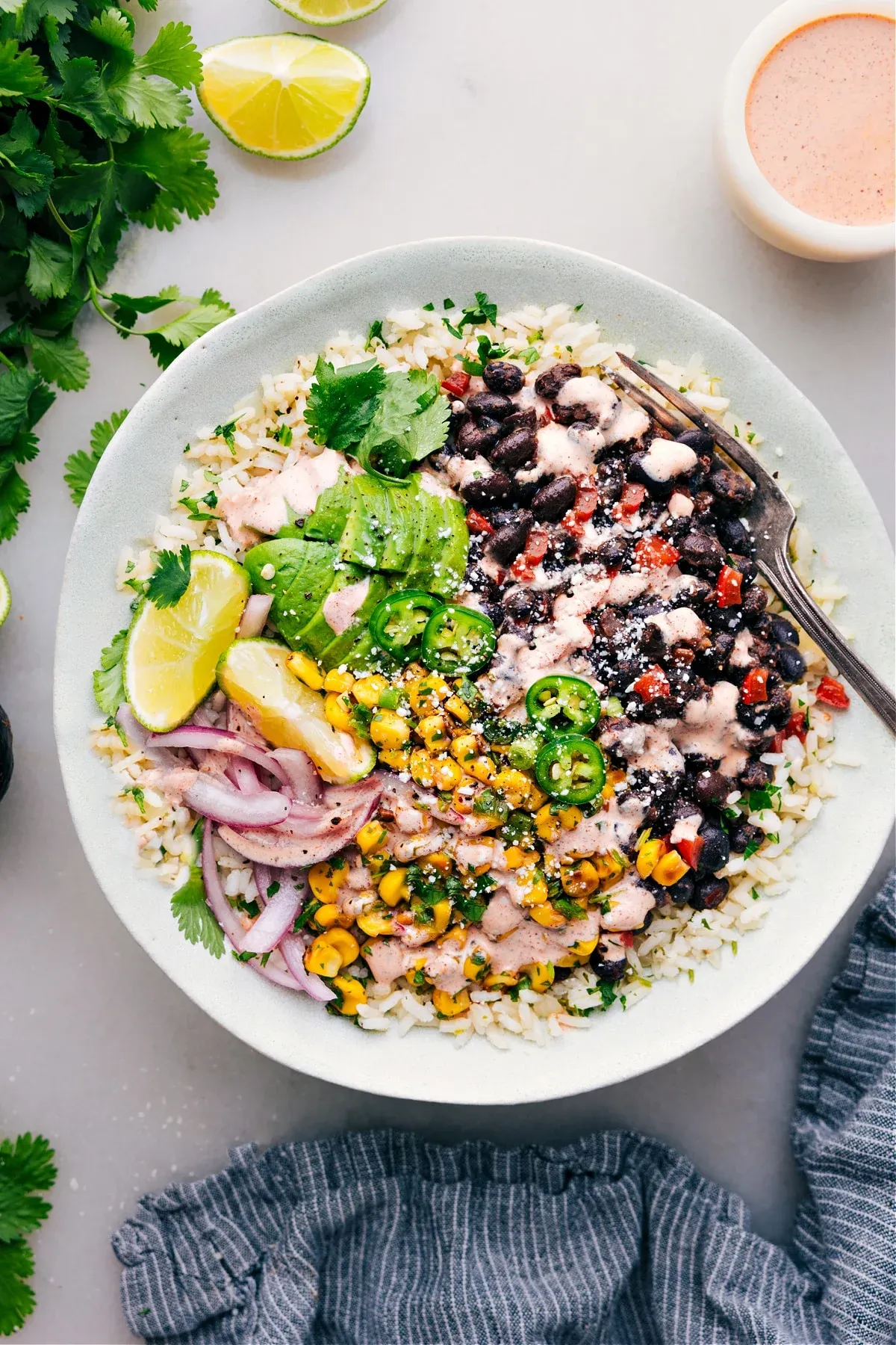 This healthy burrito bowl brings big, bold flavor with sautéed black beans spooned over fluffy cilantro-lime rice, then topped with a fresh herby corn mix and a punchy chili-lime sauce. It’s a burrito bowl recipe that feels satisfying without being heavy, making it great for quick weeknight dinners or healthy lunches for work the next day. If you’re building out a list of cheap healthy meals or easy burrito bowl meal prep ideas, this one earns its spot.