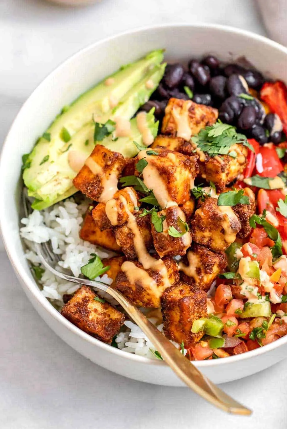 This healthy burrito bowl layers spicy baked tofu over cilantro-lime rice with roasted peppers, black beans, and creamy avocado for a plant-based burrito bowl recipe that actually feels filling. It’s a great option for burrito bowl meal prep, especially if you need healthy lunches for work that hold up well in the fridge and still taste great a few days later. If you’re looking for healthy bowls that work for both dinner and leftovers, this one fits right in.