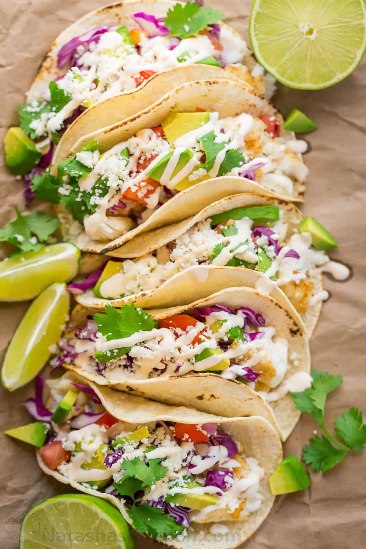 These fish tacos are a forever favorite for a reason. Soft flour tortillas are piled high with perfectly seasoned, flaky fish and loads of fresh toppings, then finished with a creamy garlic lime sauce that truly makes the whole taco sing. They’re bright, fresh, and satisfying without feeling heavy—exactly the kind of taco you crave when you want something that feels a little special but is still totally doable at home.