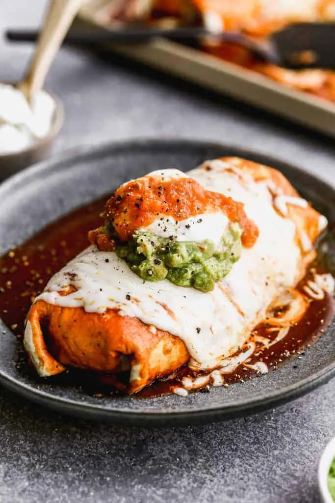 This classic wet burrito is stuffed with shredded meat, beans, rice, and plenty of cheese, all wrapped in a soft flour tortilla. It’s then smothered in red or green enchilada sauce and baked with extra cheese on top until warm and melty. A hearty, comfort-food burrito that feels extra satisfying and perfect when you want something filling and indulgent.