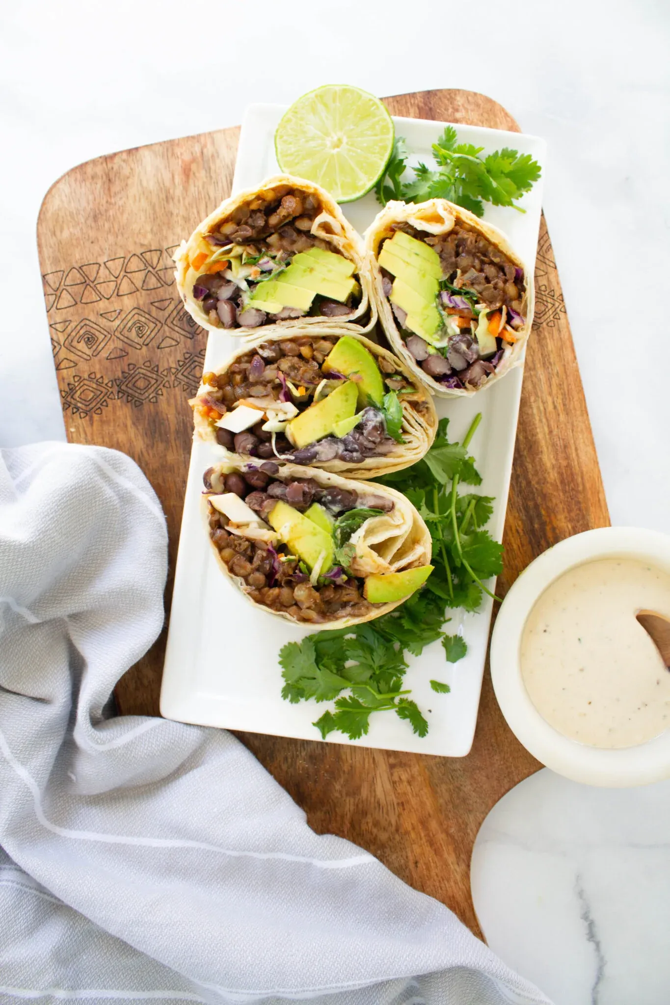 These vegan burritos are stuffed with smoky BBQ lentils, black beans, tangy slaw, creamy avocado, and a drizzle of tahini dressing. Wrapped in soft flour tortillas, they’re hearty, flavorful, and satisfying enough to please everyone at the table — a great plant-based option for an easy, comforting burrito night.