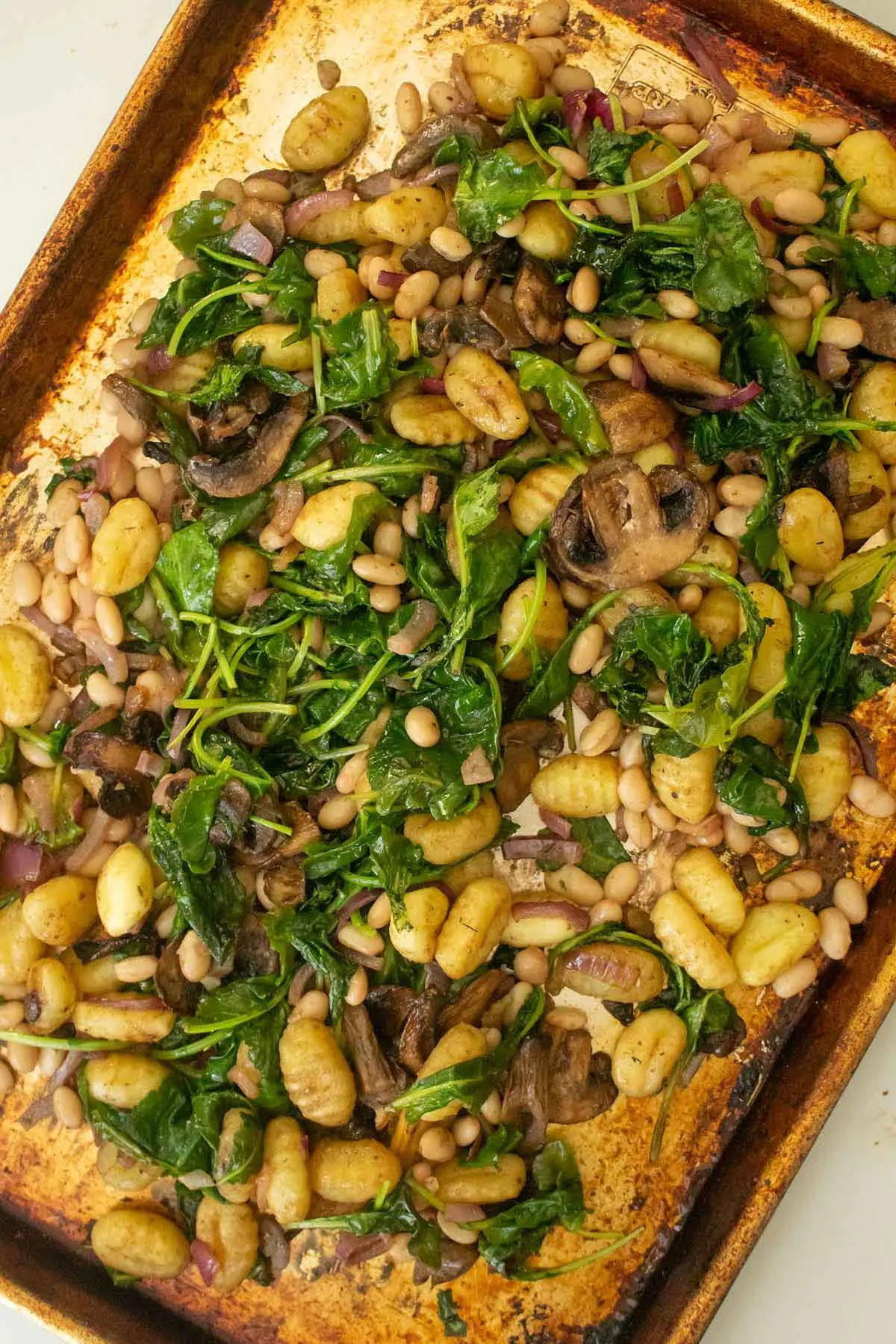 This sheet pan gnocchi with mushrooms and spinach gets those pillowy potato dumplings perfectly crisp on the outside while staying soft in the middle. Everything cooks on one pan, starting with the gnocchi and mushrooms, then finishing with spinach, white beans, and a punchy balsamic sauce. The result is a flavorful, satisfying meal with minimal prep and hardly any cleanup.