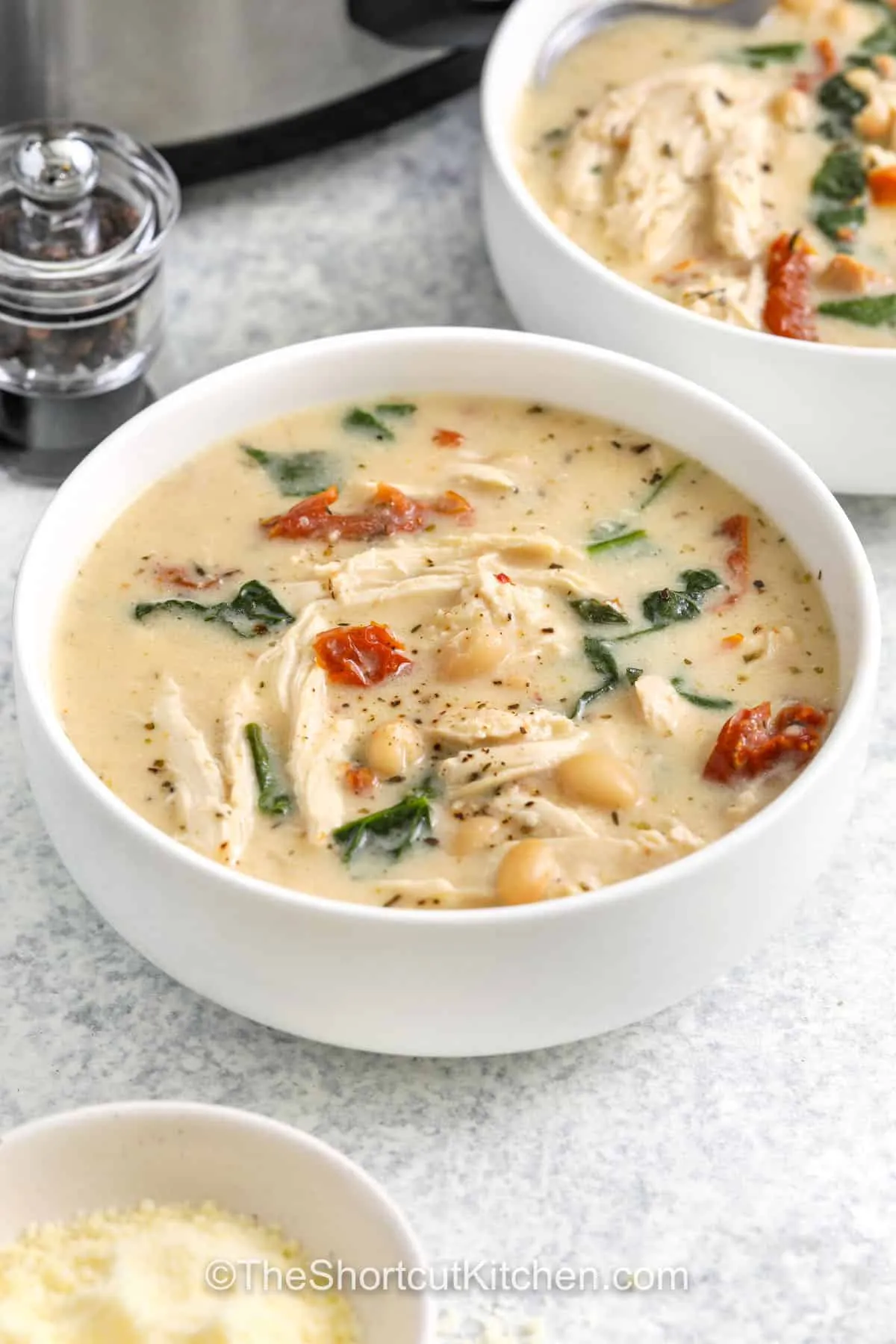 This creamy Tuscan chicken soup is rich, cozy, and packed with flavor. Tender chicken simmers with beans, sun-dried tomatoes, and spinach in a creamy broth finished with plenty of Parmesan cheese. It’s hearty, comforting, and the kind of soup that feels a little special while still being easy enough for a weeknight.